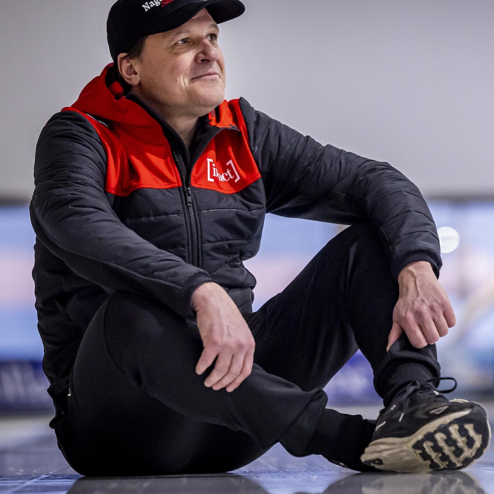 Assis sur la glace, il regarde au loin. 